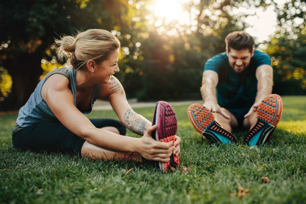 Couple stretching after a run in a park near Aston Pointe in Aston, Pennsylvania