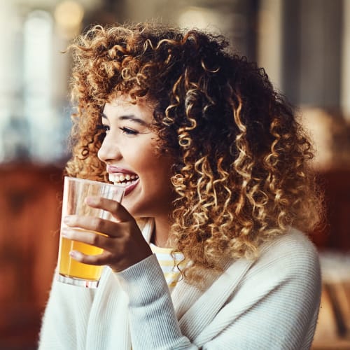 A women laughing while enjoying a drink near The Columbia at the Waterfront in Vancouver, Washington