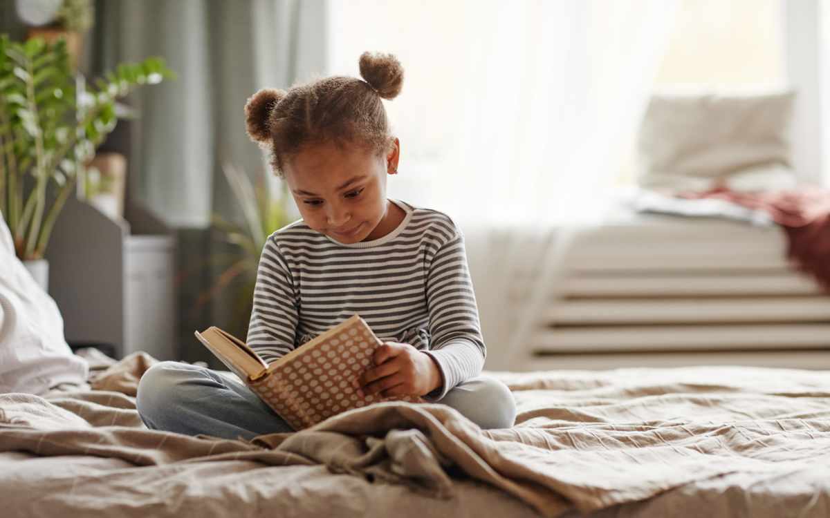 Kid reading book on bed at Redland Crossings in Naranja, Florida