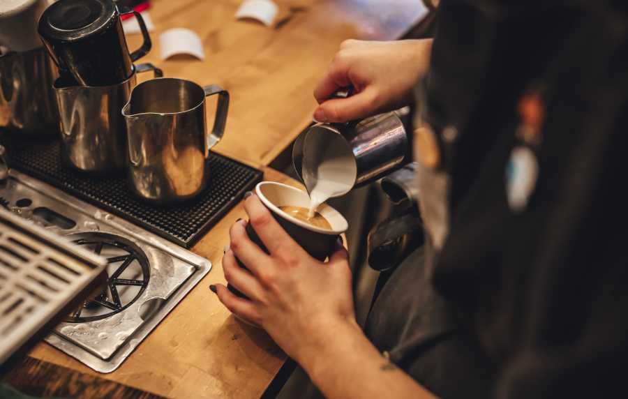 A barista preparing a cup of coffee at a coffee shop near Main Street Apartments in Bensenville, Illinois