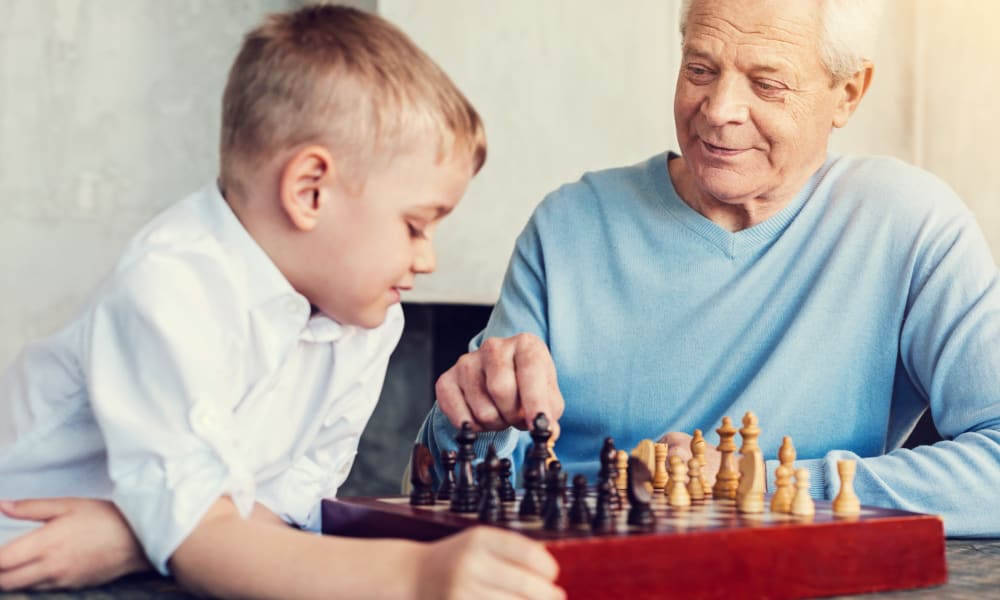 A resident playing chess with a child at Amaran Senior Living in Albuquerque, New Mexico. 