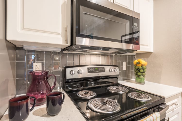 Beautiful kitchen counter tops with a tile back splash at Sage at 1825 Apartments in Pflugerville, Texas