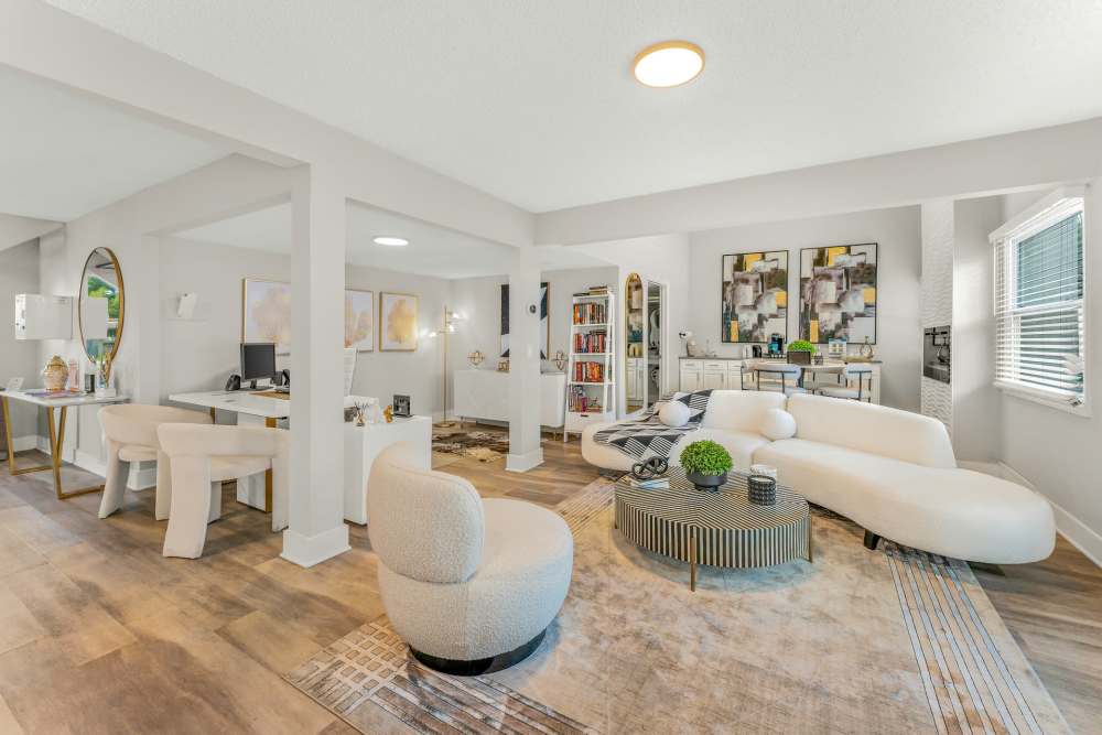 Interior View Of An Open-Concept Living Space With A Home Office, White Furniture, And Wood Floors at The Palms at Casselberry in Casselberry, Florida
