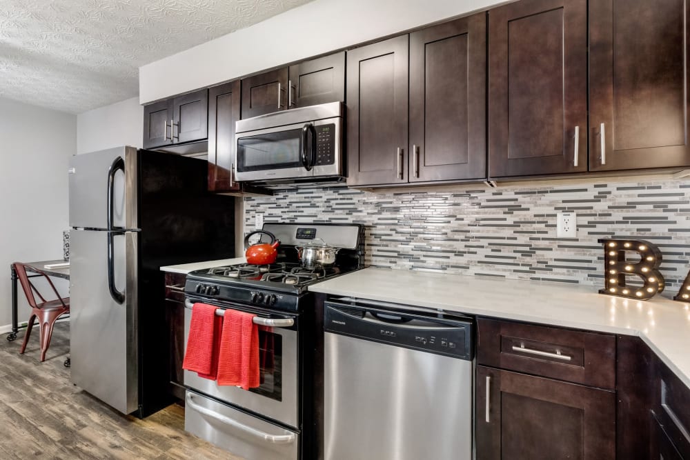 An apartment kitchen with a tile backsplash at Fox and Hounds Apartments in Columbus, Ohio