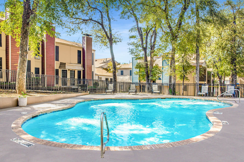 Elegant pool with trees in back at Estancia Estates in Dallas, Texas