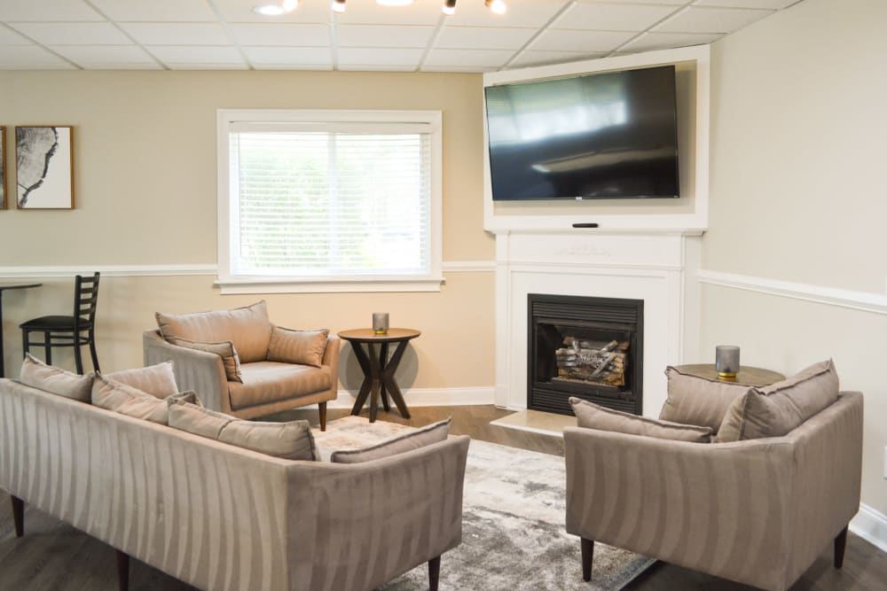 Lounge area with a fireplace and a wall mounted tv at The Village at Voorhees in Voorhees, New Jersey