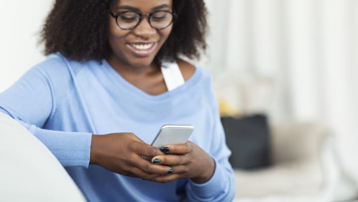 Smiling woman using smartphone