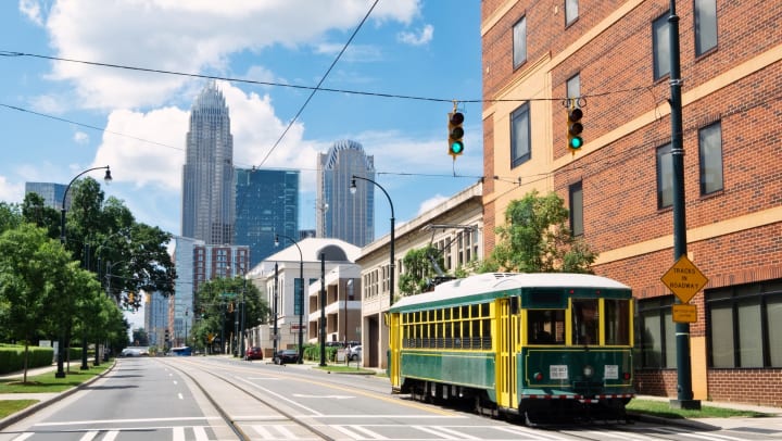 Charlotte, NC, street with a streetcar and skyscrapers in the background.
