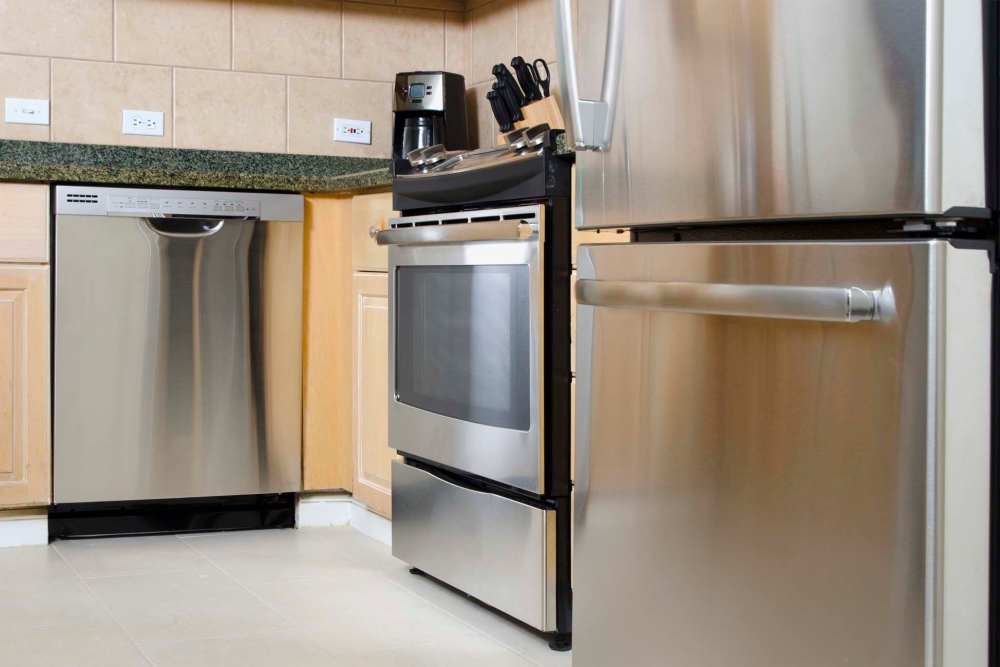 Kitchen with appliances including refrigerator, microwave, dishwasher and cupboard storage at Athens Vista Senior Apartments in Los Angeles, California
