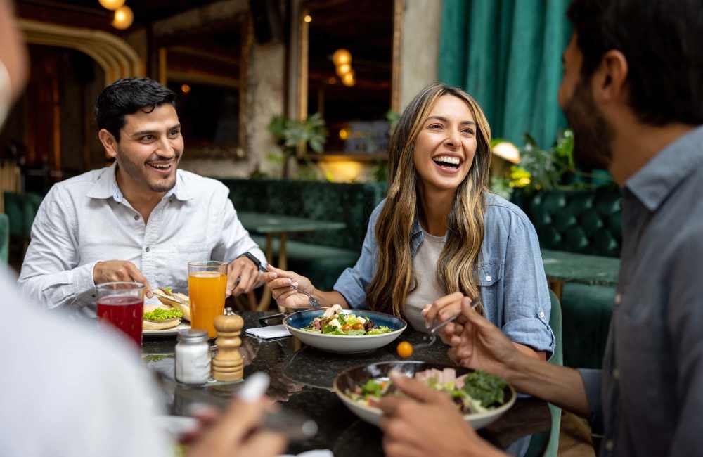 Group enjoying a vibrant meal in a cozy restaurant setting at Avian Place Apartments in North Charleston, South Carolina 