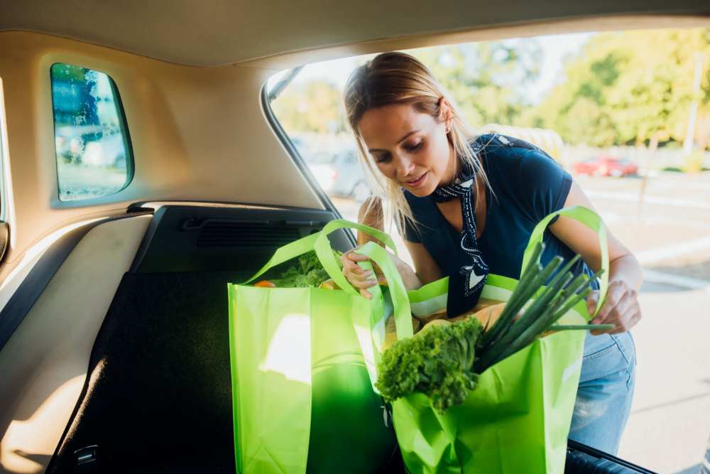 Woman carrying fresh produce and putting in her car at Miller Landing in Cleveland, Tennessee