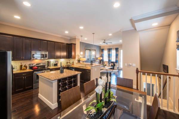 A kitchen having stainless-steel appliances and access to dining area at Perry Row in Dallas, Texas         
