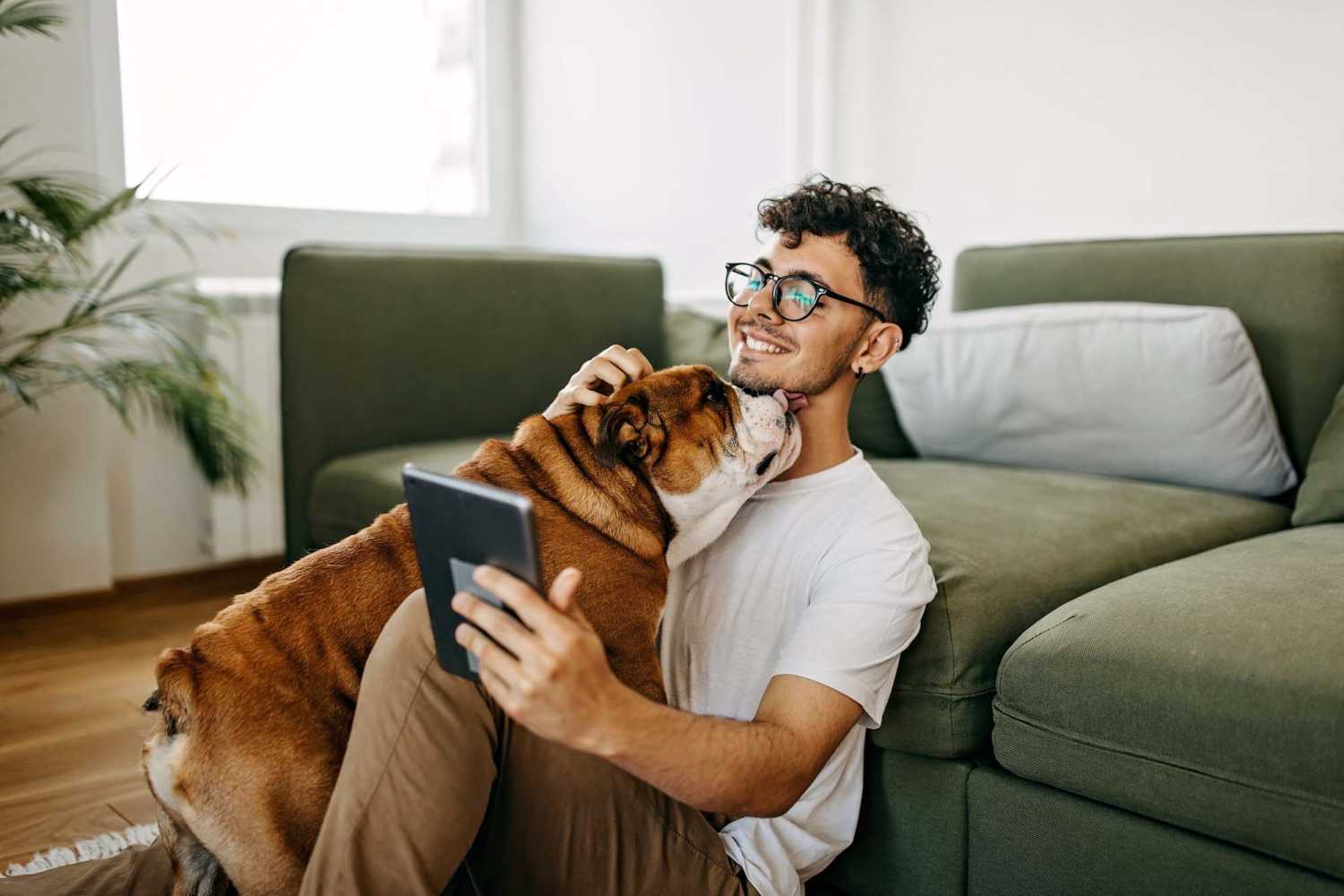 Resident man playing with his pet dog in their apartment at Villas At Swannanoa in Swannanoa, North Carolina