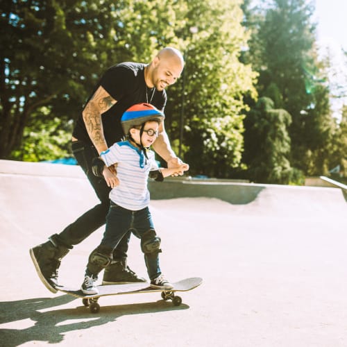 A father teaching his son how to skate near Fairway Heights in Twentynine Palms, California