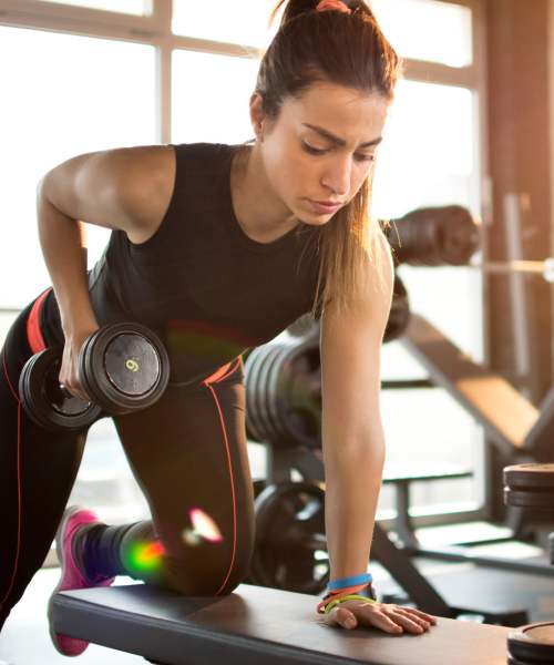 Woman holding dumbbells in the fitness center at The Kensington in Charlotte, North Carolina
