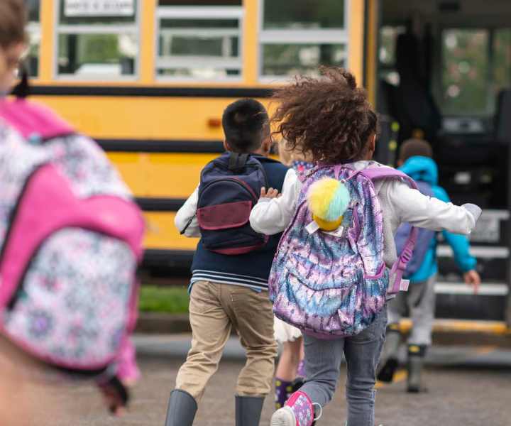 Kids running towards school bus at Fulton Hill Apartments in Tallahassee, Florida