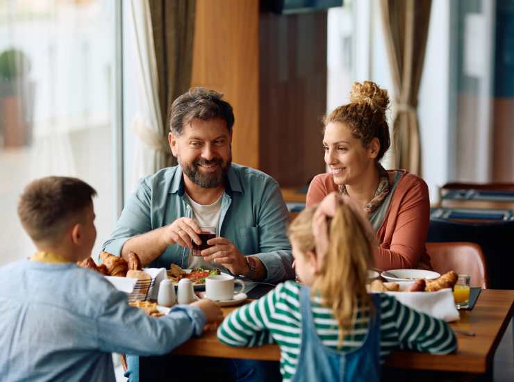 A happy family enjoying food in a restaurant near Orchard Trace Lagrange in Lagrange, Georgia