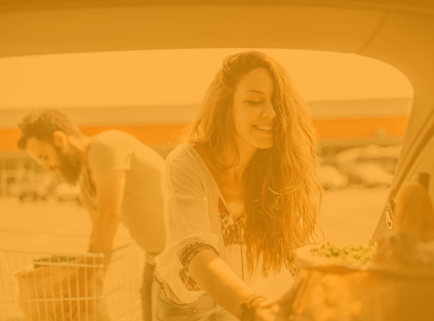 Happy couple holding grocery bag near Amber Glen Apartments in Everett, Washington