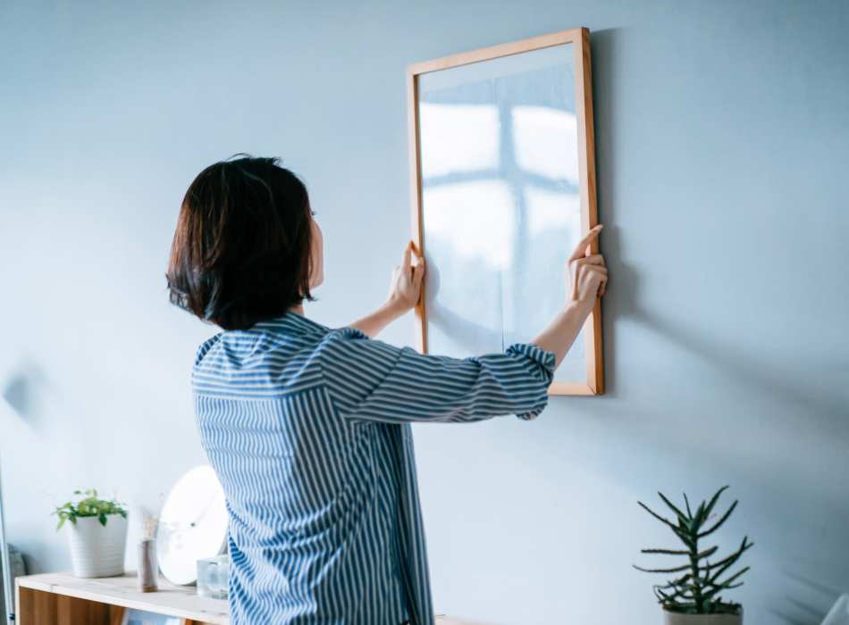 Woman putting photo on the wall near Breckinridge Point Apartments in Richardson, Texas