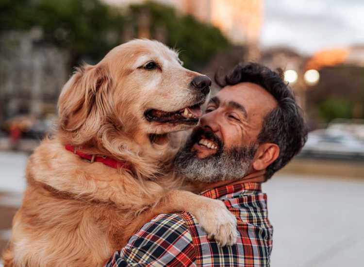 Happy resident holding his dog at Edgewater Apartments in Westport, Massachusetts