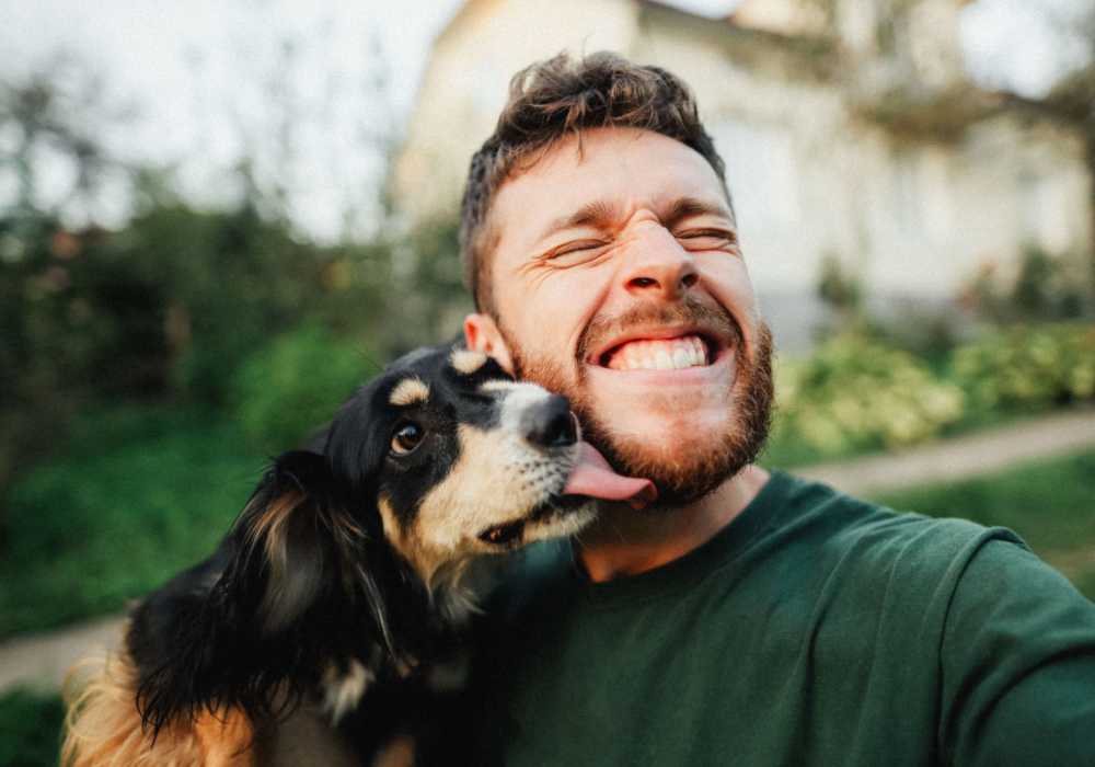 Resident getting licked by his dog in their pet-friendly home at Maple Leaf Apartments in Merrillville, Indiana