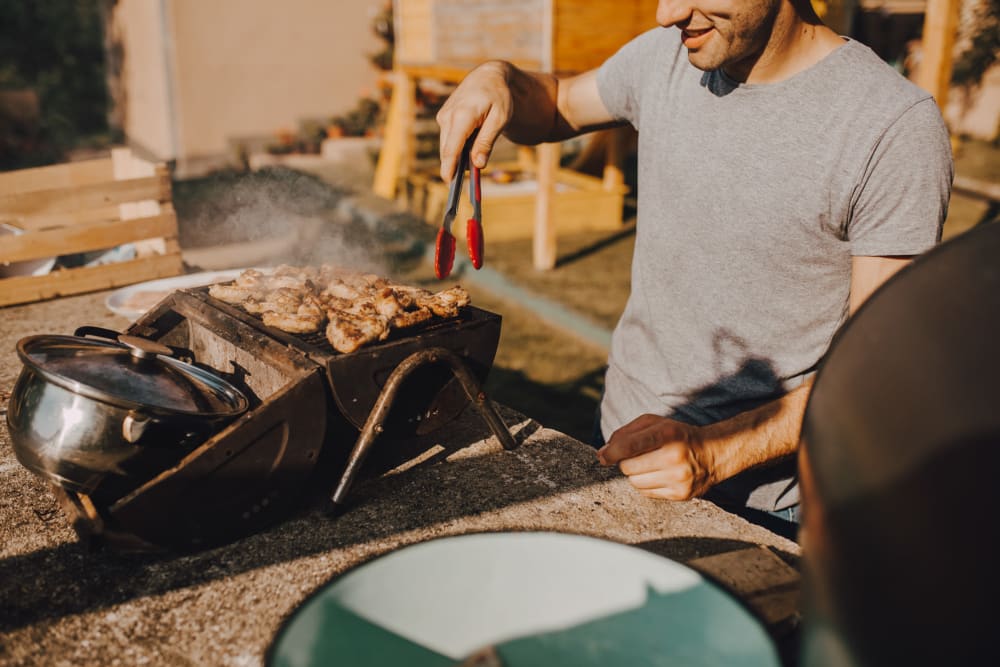 A resident cooking at a grill at Fairway Heights in Twentynine Palms, California