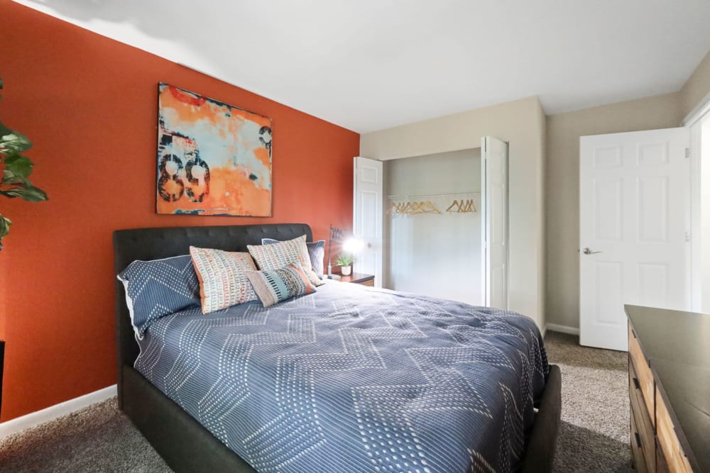Bed with orange wall at The Seasons Apartments in Laurel, Maryland