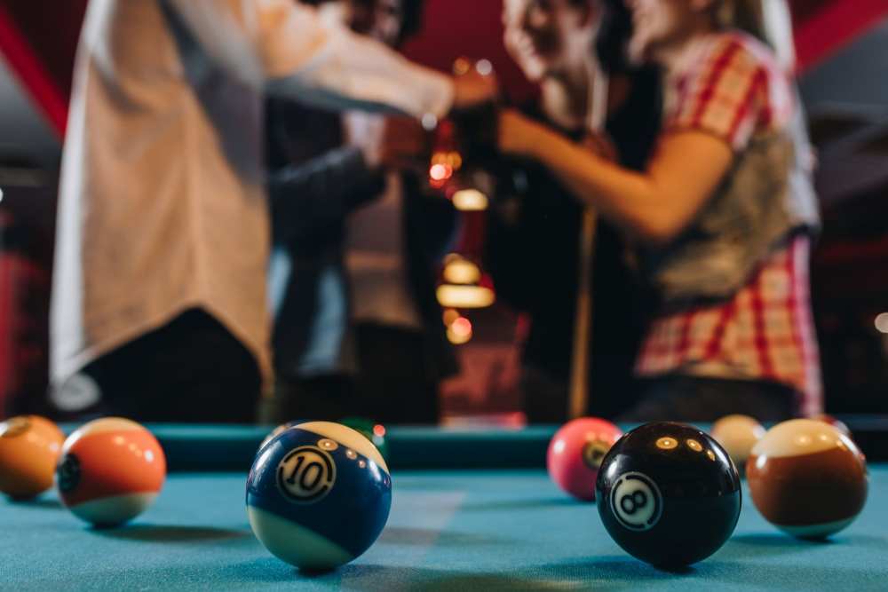 Residents playing pool nearby at a Bar at The Abbey at Veramendi in New Braunfels, Texas