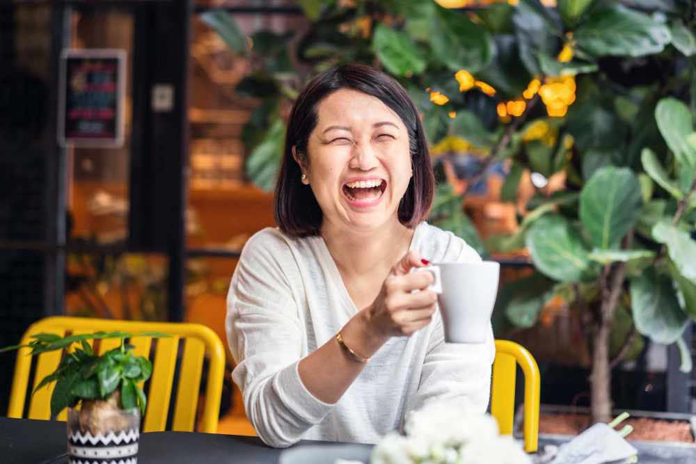 Resident drinking coffee and laughing at Vista Rose Apartments in Wasilla, Alaska