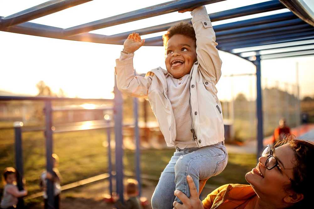 Resident woman playing with her child in a playground at Hampton Square in Cherry Hill, New Jersey