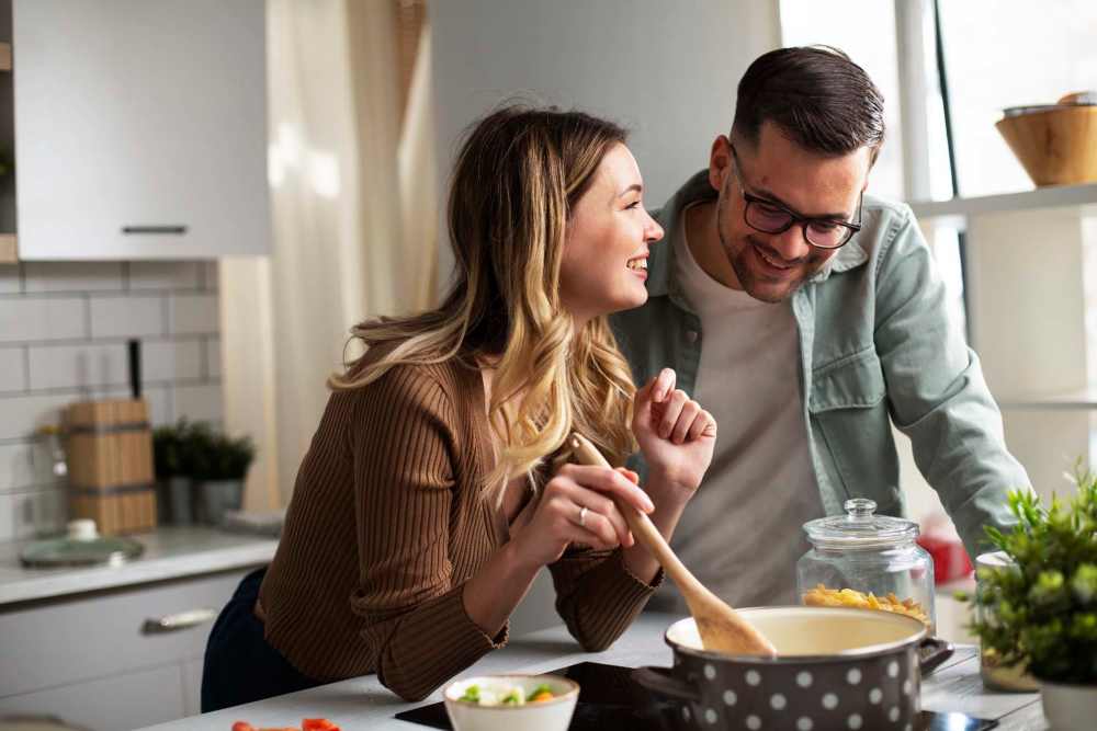 Kitchen with couple cooking together at Pointe Inverness in Fort Wayne, Indiana