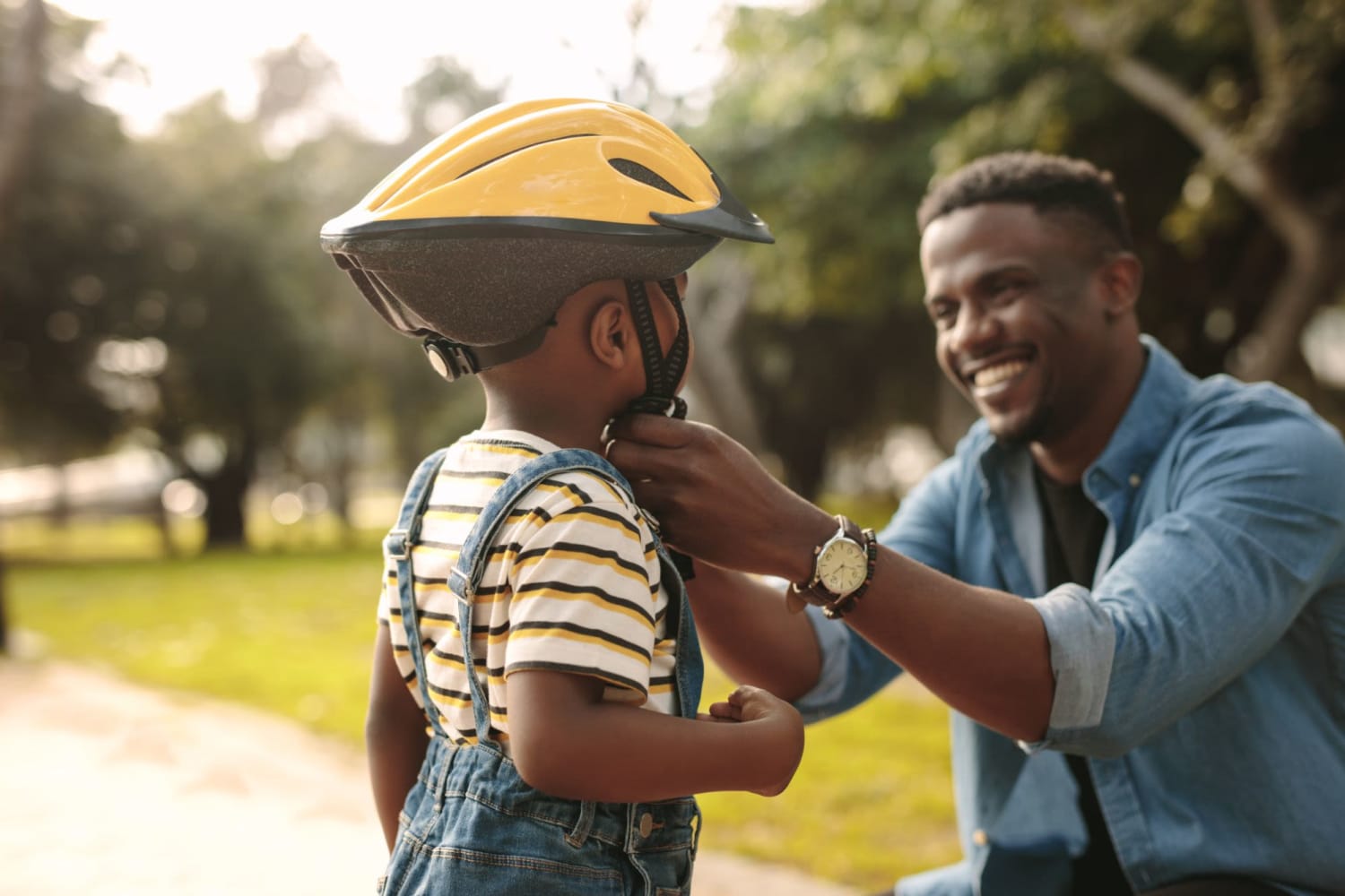 Dad putting a bike helmet on his son at Wisdom Place in Modesto, California