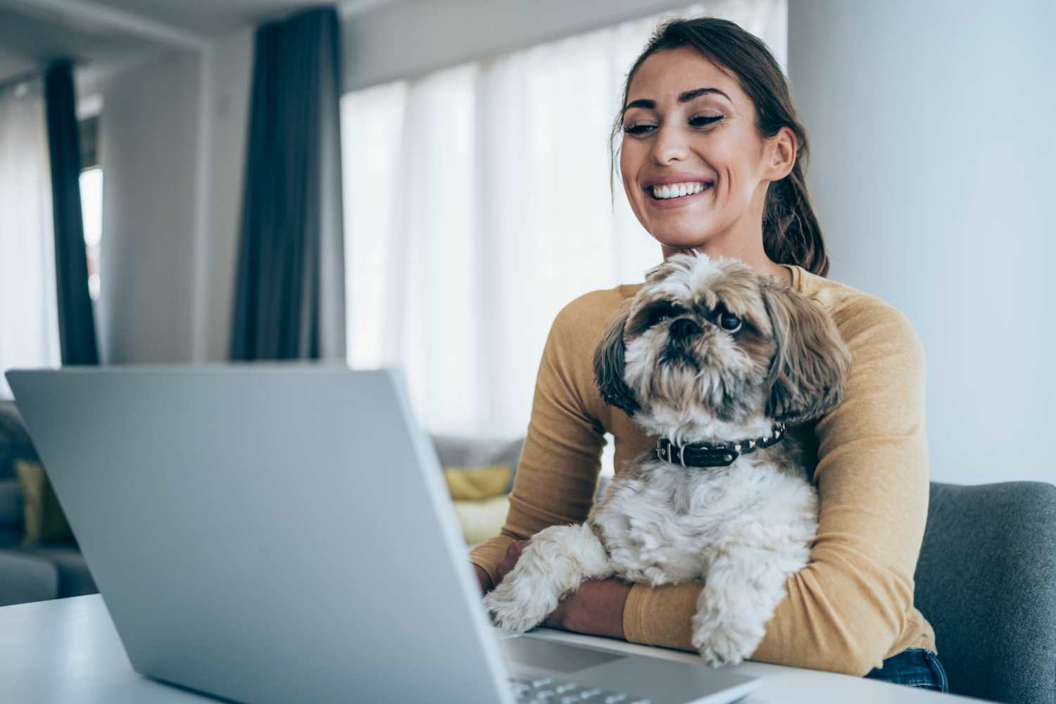 Resident and her pet watching her laptop in her apartment at Navasota Manor Apartments in Navasota, Texas