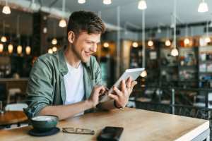 A man using his tab with a cup of coffee near Brookstone Park Of Seminole in Seminole, Oklahoma