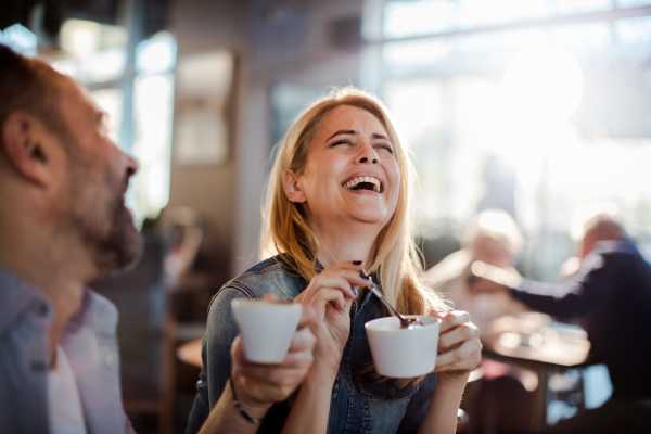 A couple lauging, over a cup of coffee in a cafe near Prosper 83 in Sparks, Nevada