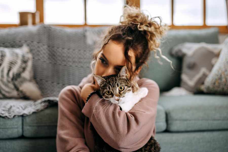 Woman hugging her cat in her home at St. Michael's Apartments in Riverside, California