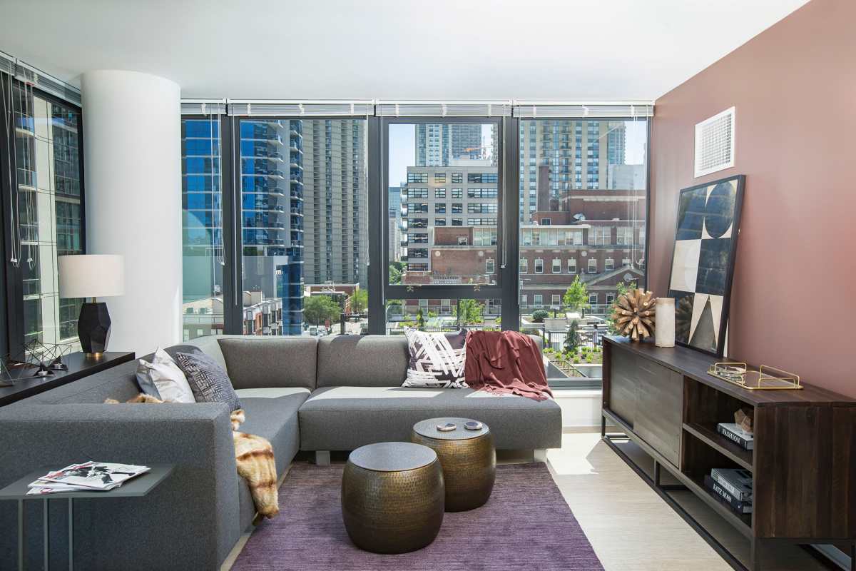 Apartment living area with large windows at Exhibit On Superior in Chicago, Illinois