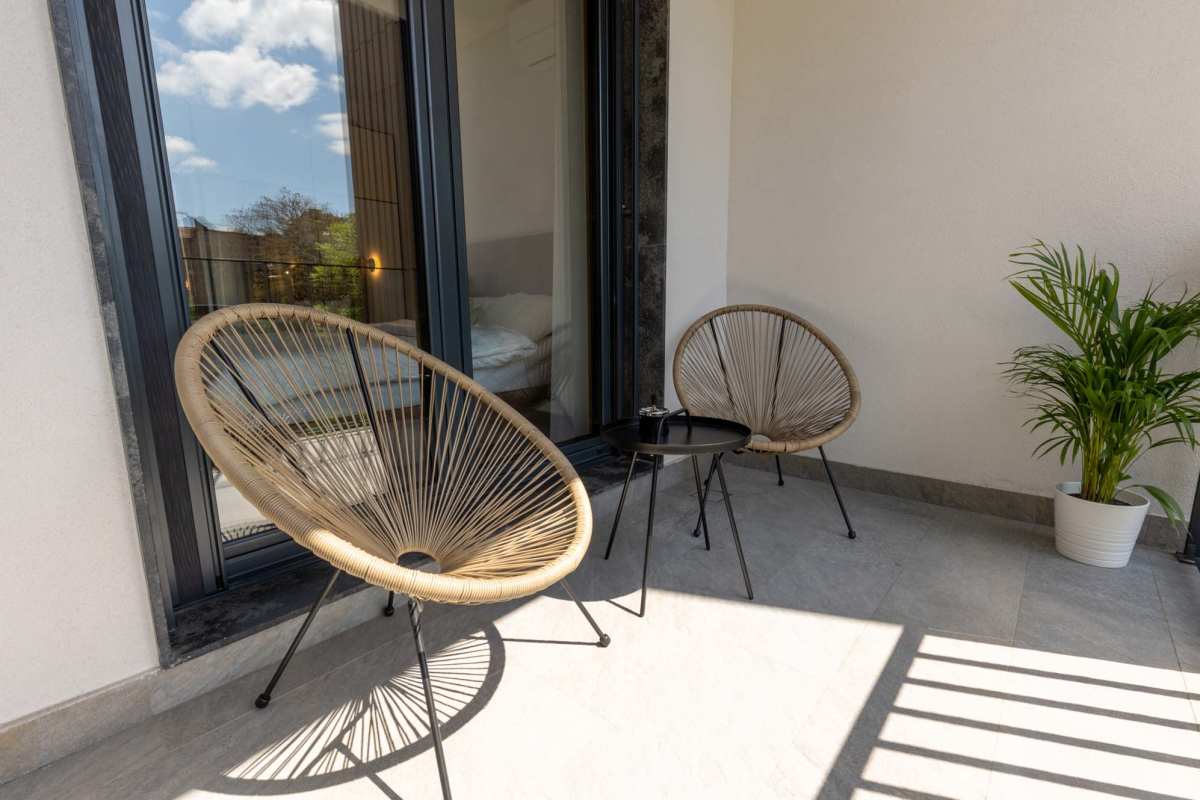 Charming balcony retreat featuring stylish seating, serene ambience, and a touch of lush greenery  at Prairie Hill Estates II in Carl Junction, Missouri 