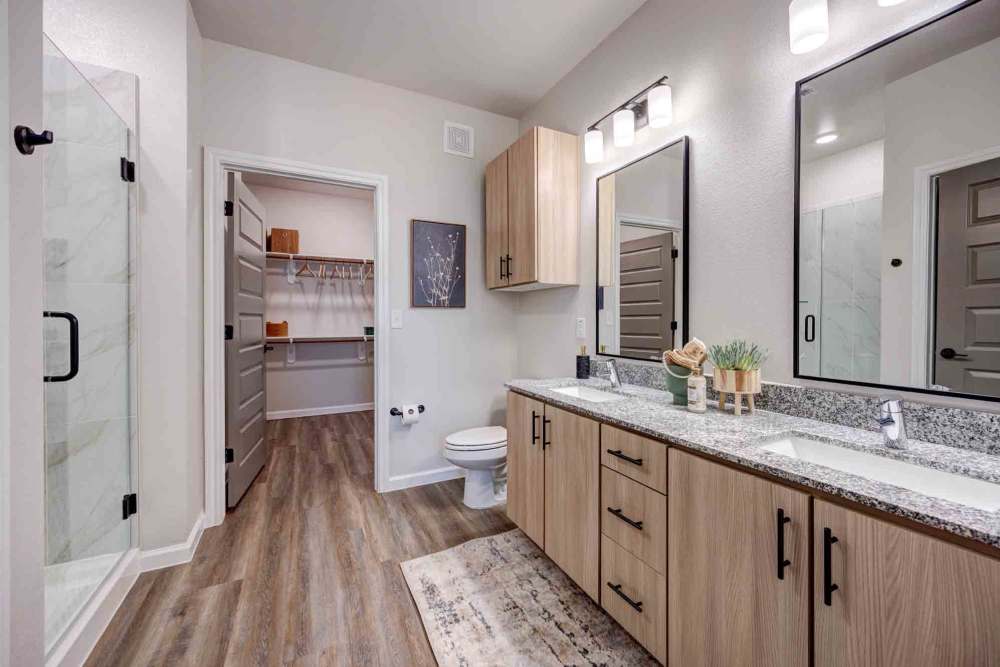Modern bathroom's double vanity with granite countertop at The Abbey at Veramendi in New Braunfels, Texas