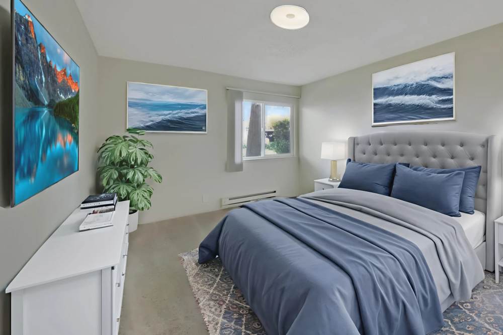 Spacious bedroom with wall art and windows at Lakeside Village in San Leandro, California