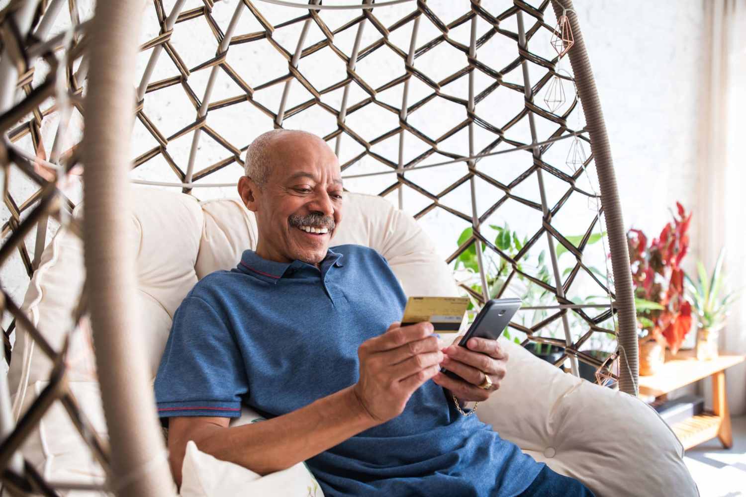 Happy resident checking his phone at Mill Pond Apartments (Buchanan) in Buchanan, Michigan