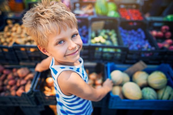 A child standing in front of produce bins at a store near Commons at Briarwood Park in Brookhaven, Georgia