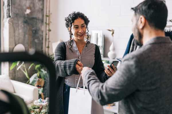 Resident handing over her credit card to a cashier at a downtown boutique near Hamptons of Norton Shores in Norton Shores, Michigan