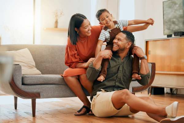 Happy family sitting in the living room at Raystone Apartments in Phoenix, Arizona