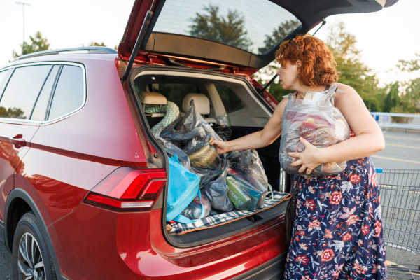 Woman loading groceries in to the trunk of her car in a parking lot at Presidential Estates in Rochester, New York