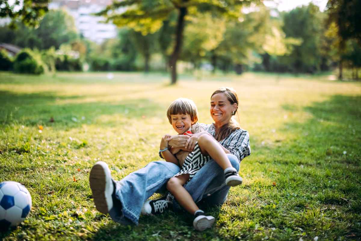 Resident enjoying with her child in the park near Tenants Development Corporation III, LP in Boston, Massachusetts