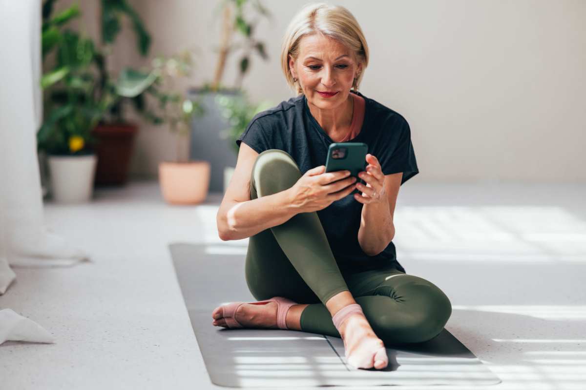 Resident using her phone while doing yoga at Ashton Walk in Forest Park, Georgia