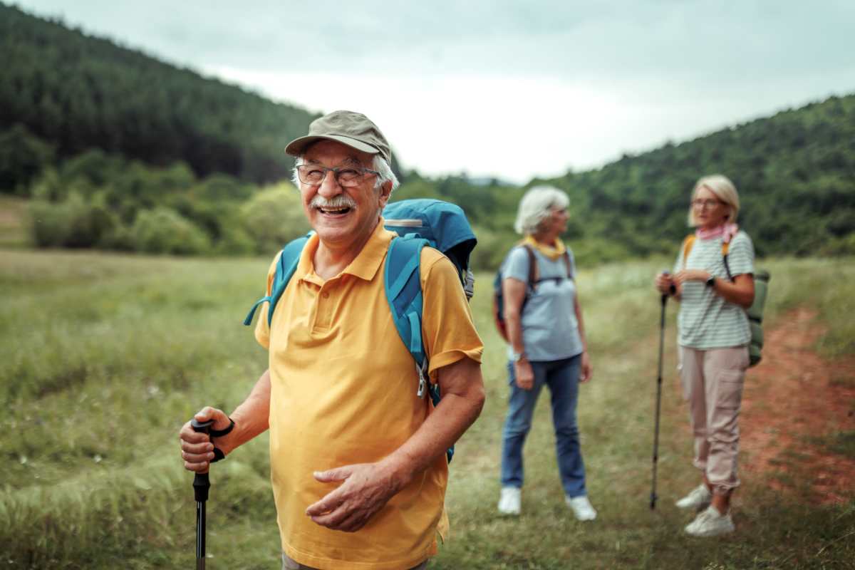  Residents hiking on grassy trail with backpacks near Hill Court Villas in Granbury, Texas