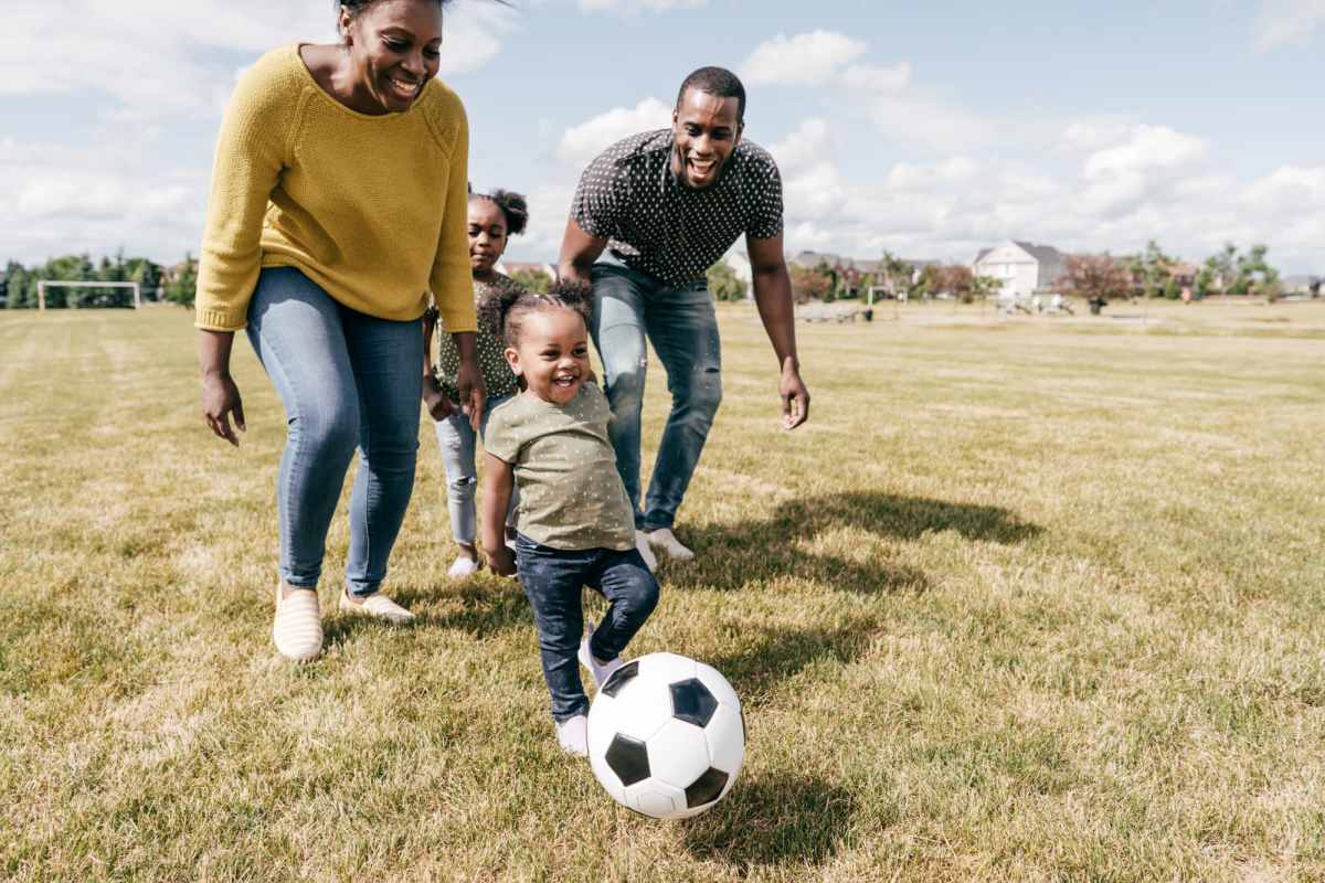 Family playing soccer in grassy field near The Towns at Patuxent Overlook in Lexington Park, Maryland 