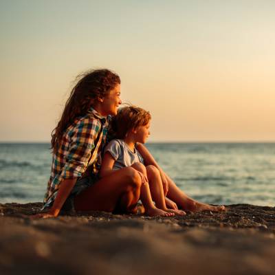Woman and child sitting by the ocean near Eagle Ridge Circle in Rochester, New York